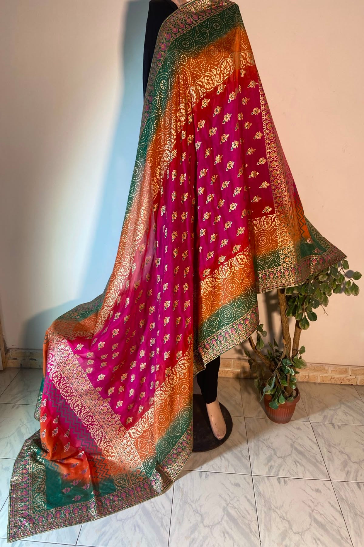 Vibrant fuchsia magenta raw silk dupatta with heavy gold block printing and multi-colored green and orange borders displayed on a mannequin