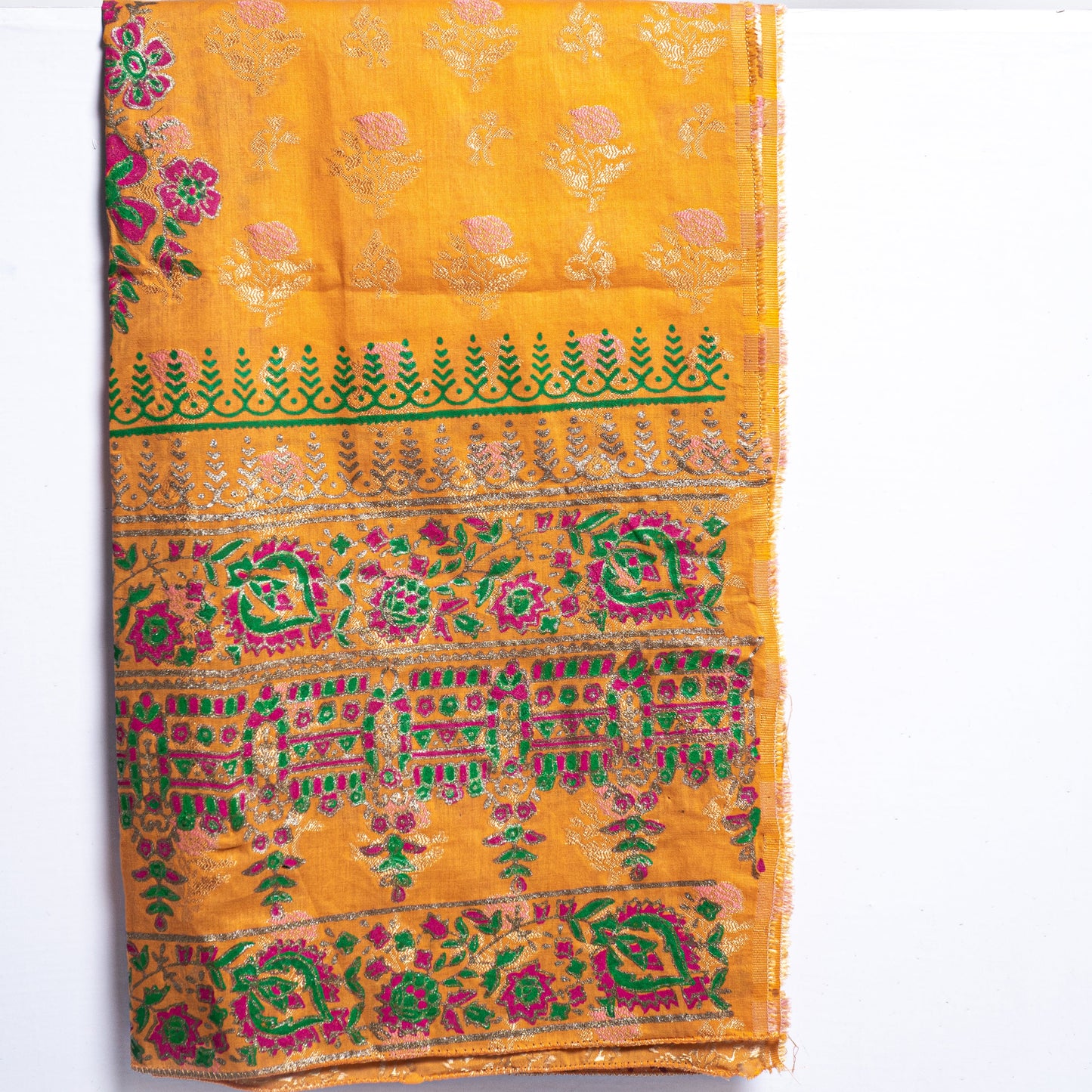 Close up of handmade block print design on mustard raw silk shirt fabric with a contrasting multi-color pink and green fine medium silk dupatta by Zariyat by Sumera.