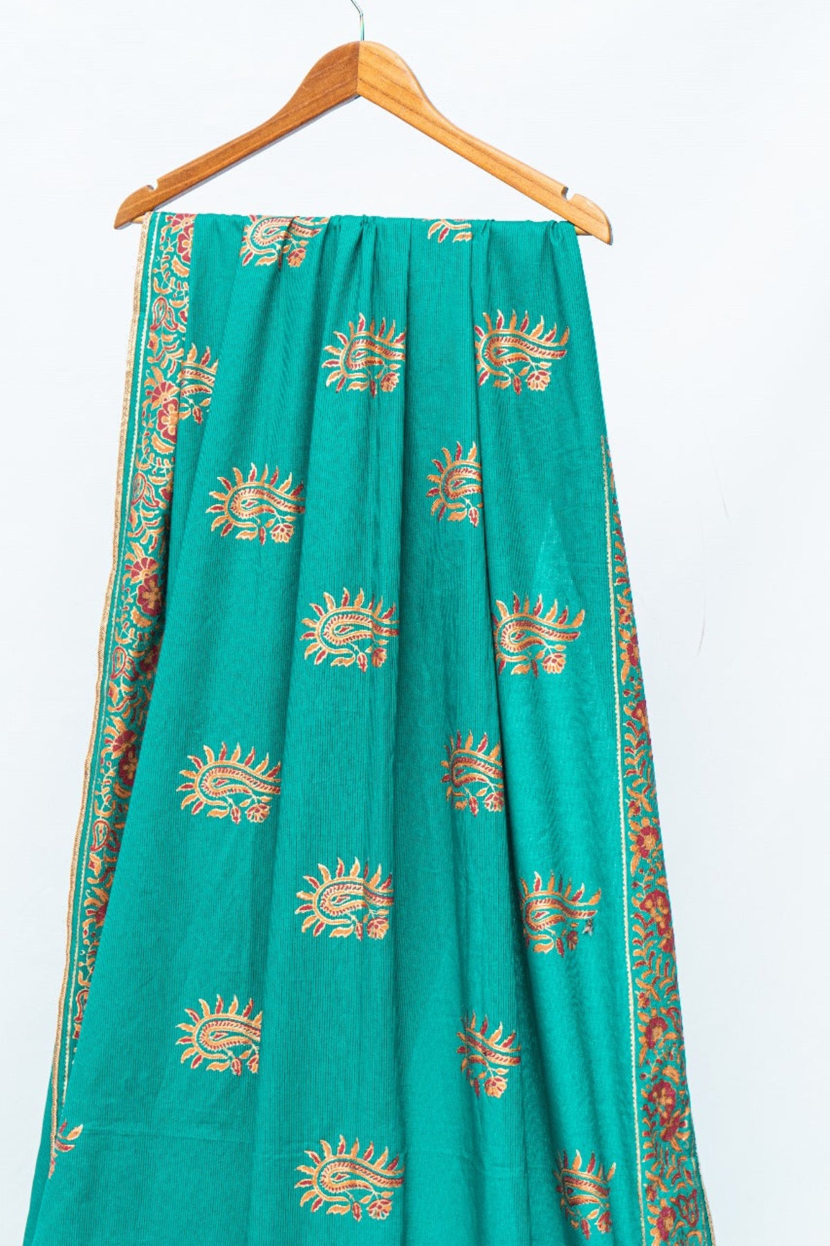 Hanging teal green lawn saree showcasing detailed traditional borders and block print design by Zariyat by Sumera.