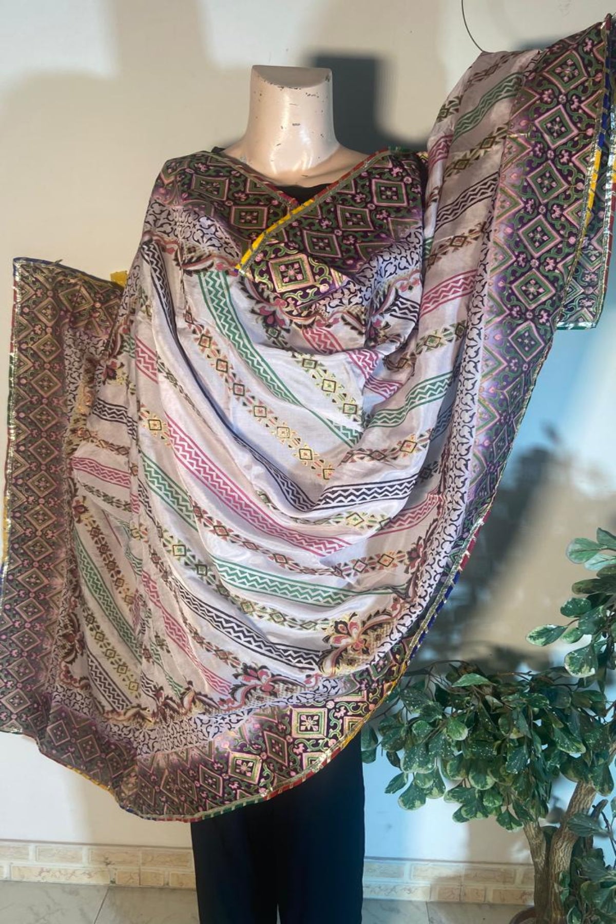 Draped view of multi-color silk dupatta with traditional block print and four-sided golden massuri trim