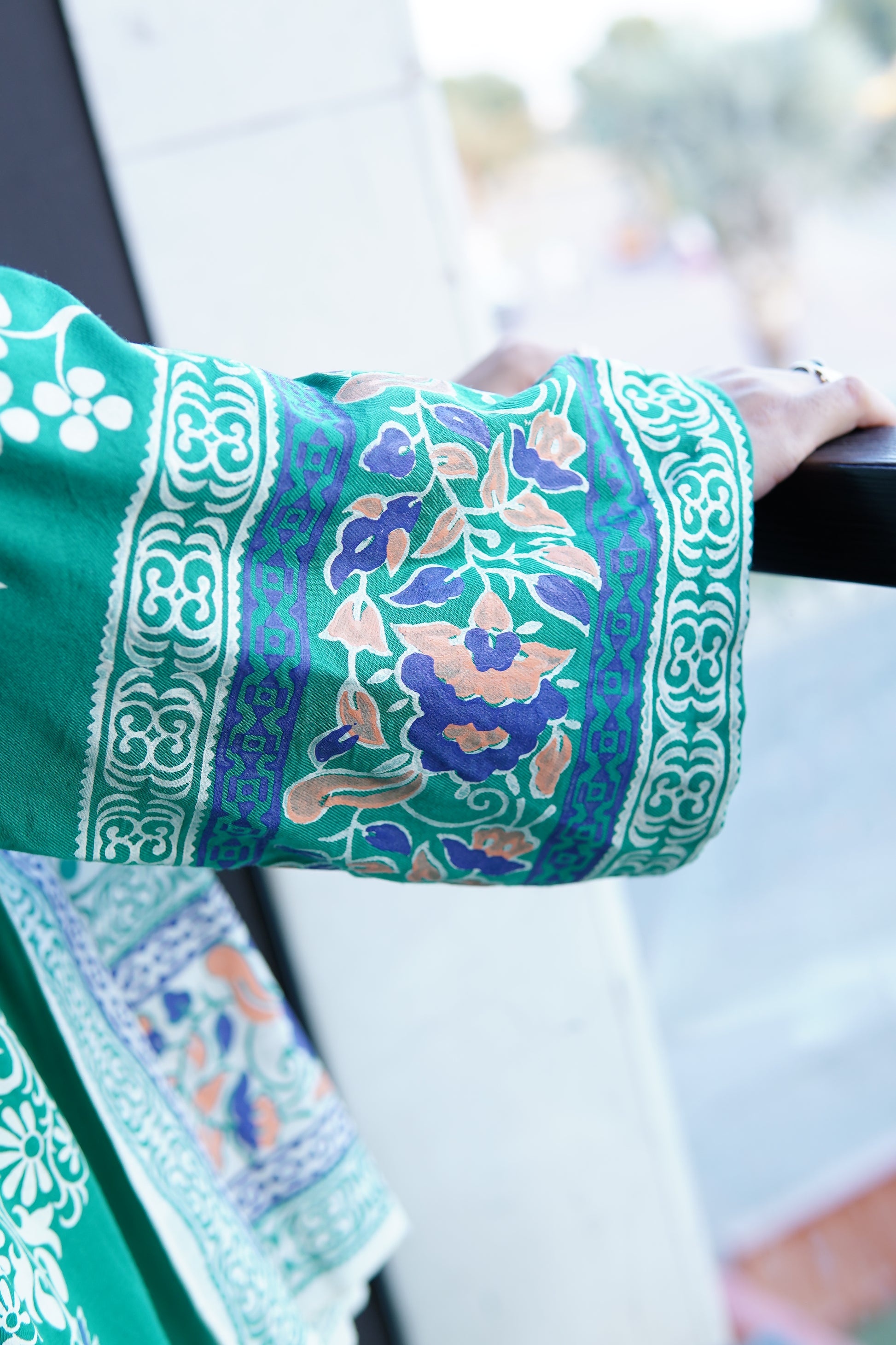 Detailed view of off white fine lawn dupatta with intricate green block printed border motifs.