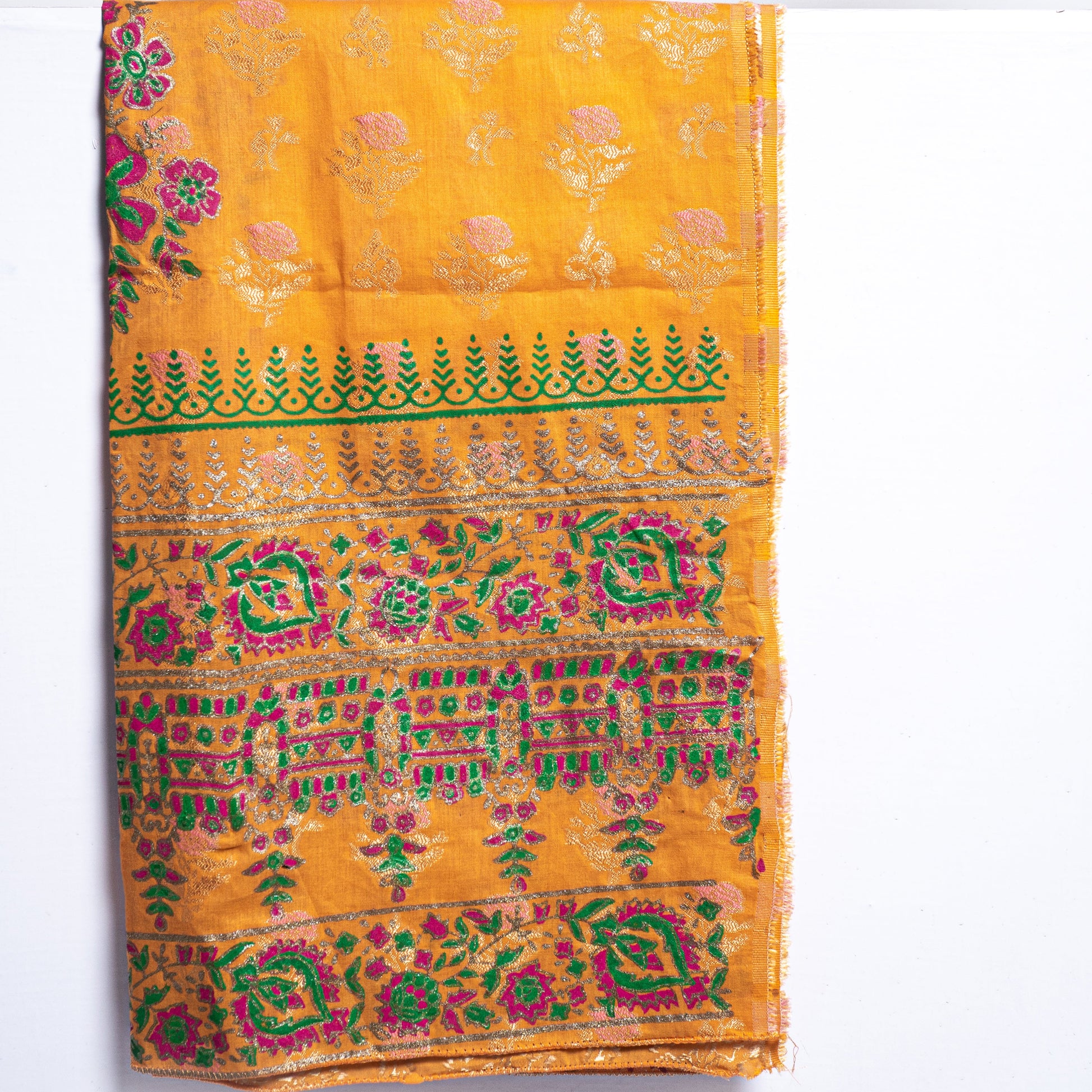 Close up of handmade block print design on mustard raw silk shirt fabric with a contrasting multi-color pink and green fine medium silk dupatta by Zariyat by Sumera.