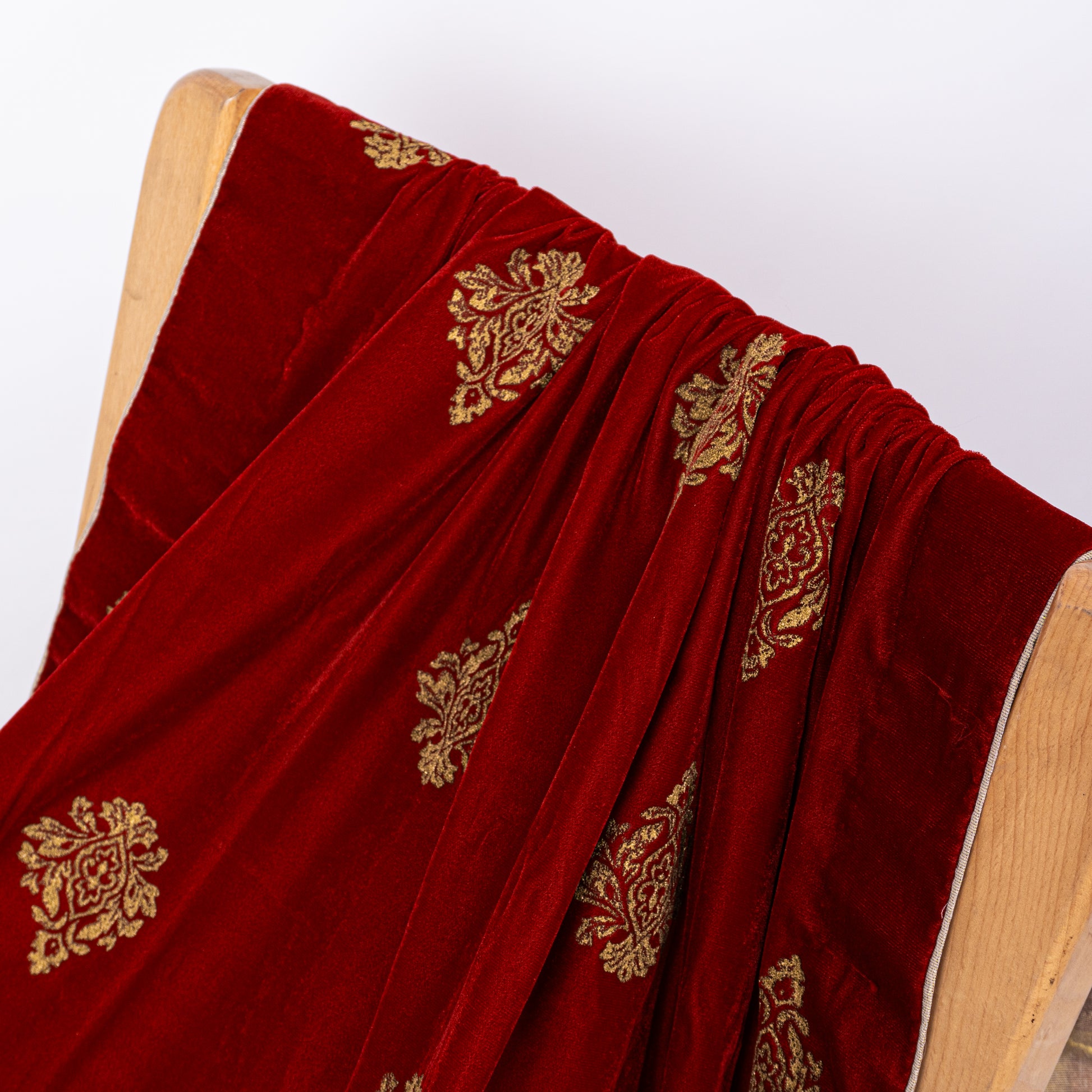 Elegant drape of a premium winter velvet shawl in maroon with shimmering gold prints for formal wedding wear
