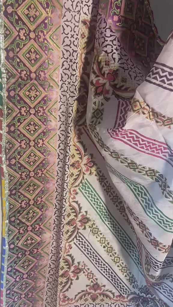 Close-up of premium silk dupatta showing intricate multi-color patterns and golden massuri inner layer.