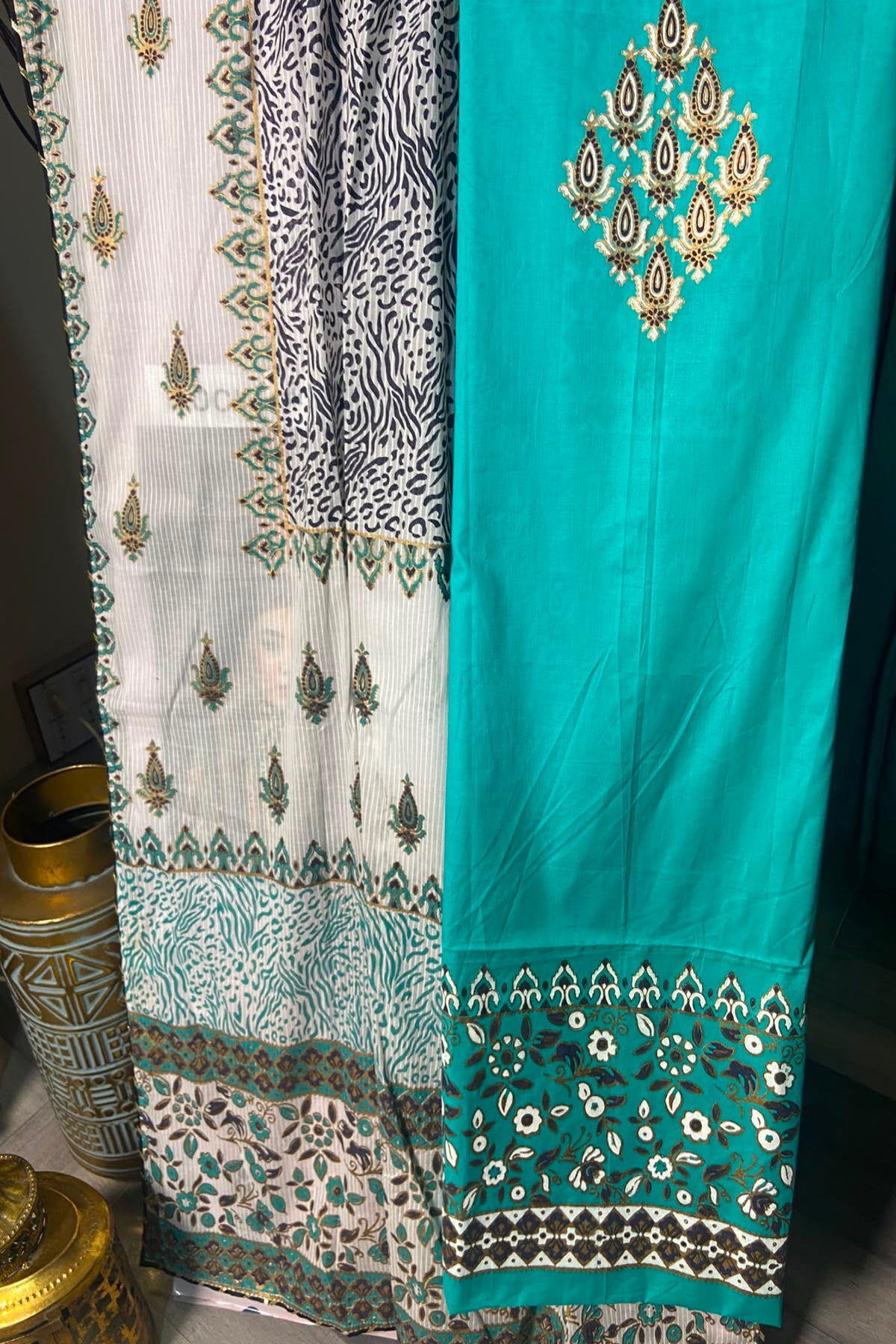 Close-up of the vibrant turquoise shirt front with detailed neckline embroidery and printed borders.