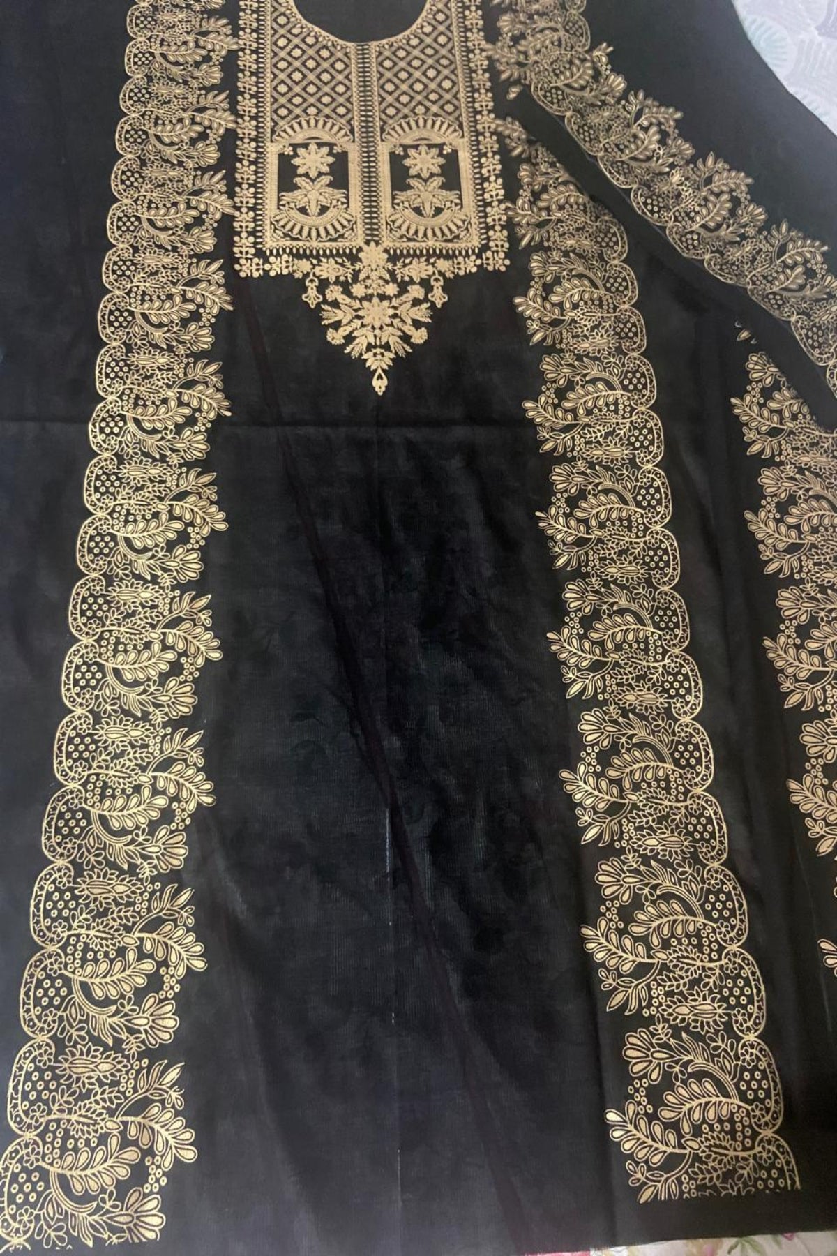 Close-up view of black and gold unstitched designer shirt on fine lawn and raw silk fabric
