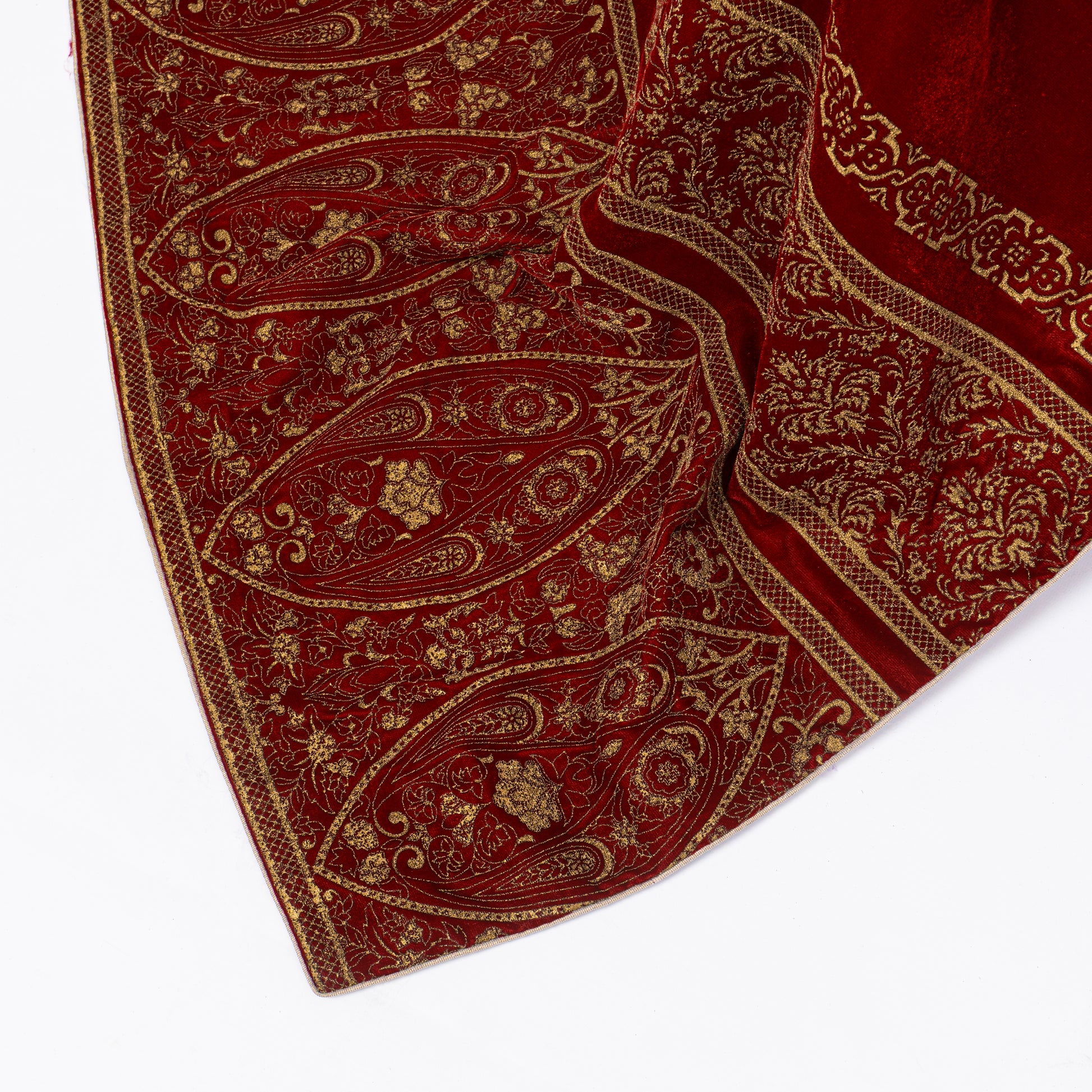Detailed shot of intricate golden paisley and floral screen print border on a premium maroon velvet shawl.