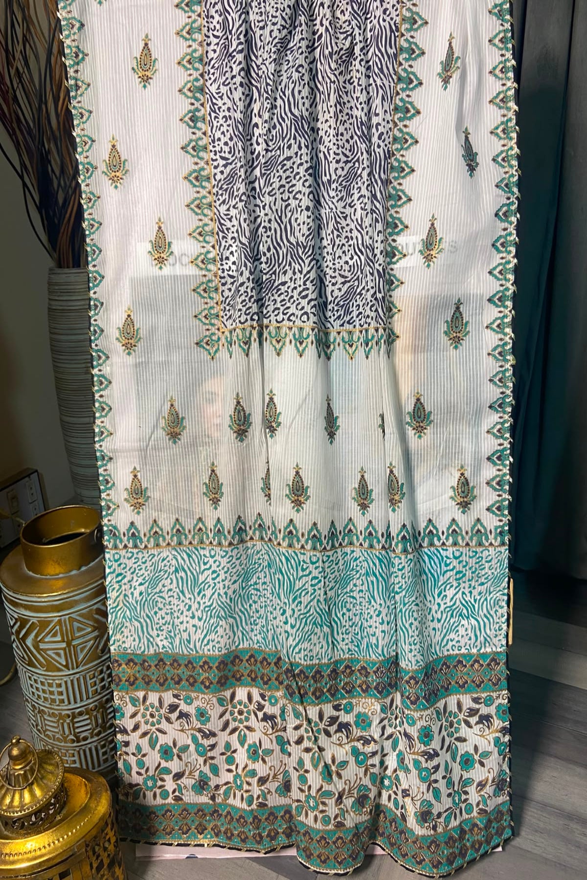 Detailed view of the white and teal patterned dupatta featuring traditional motifs and animal print accents.