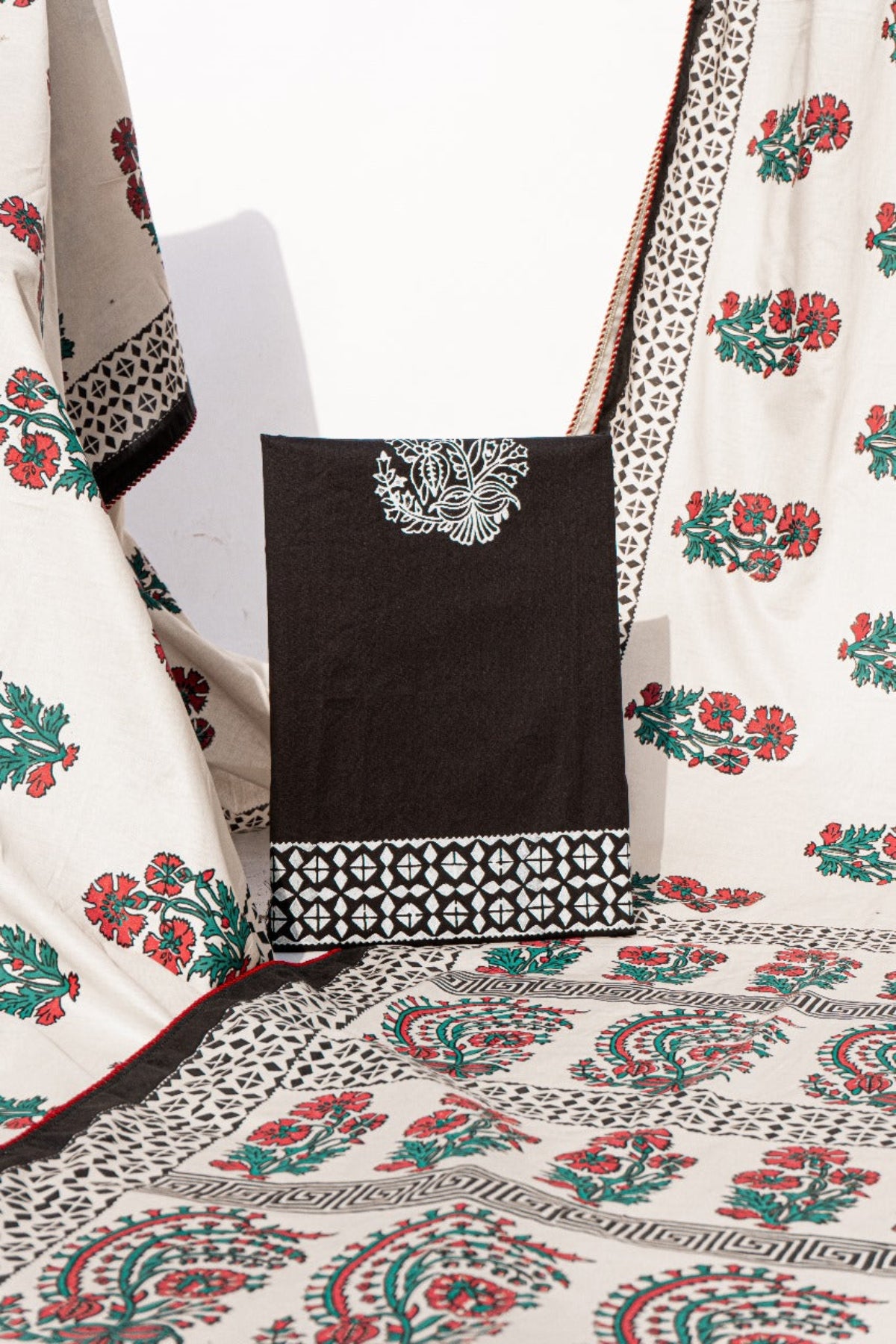 Detailed view of traditional paisley floral block print on off-white and black lawn fabric for a designer saree