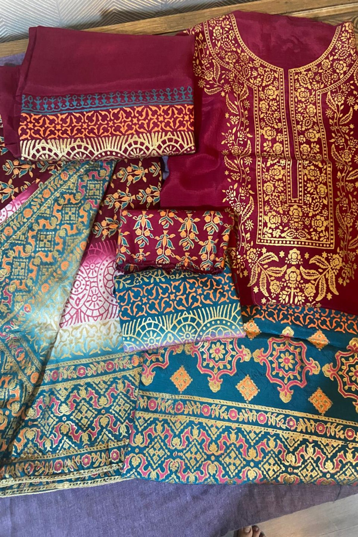 A magenta raw silk lawn suit from Zariyat by Sumera featuring intricate block print patterns paired with a printed dupatta.