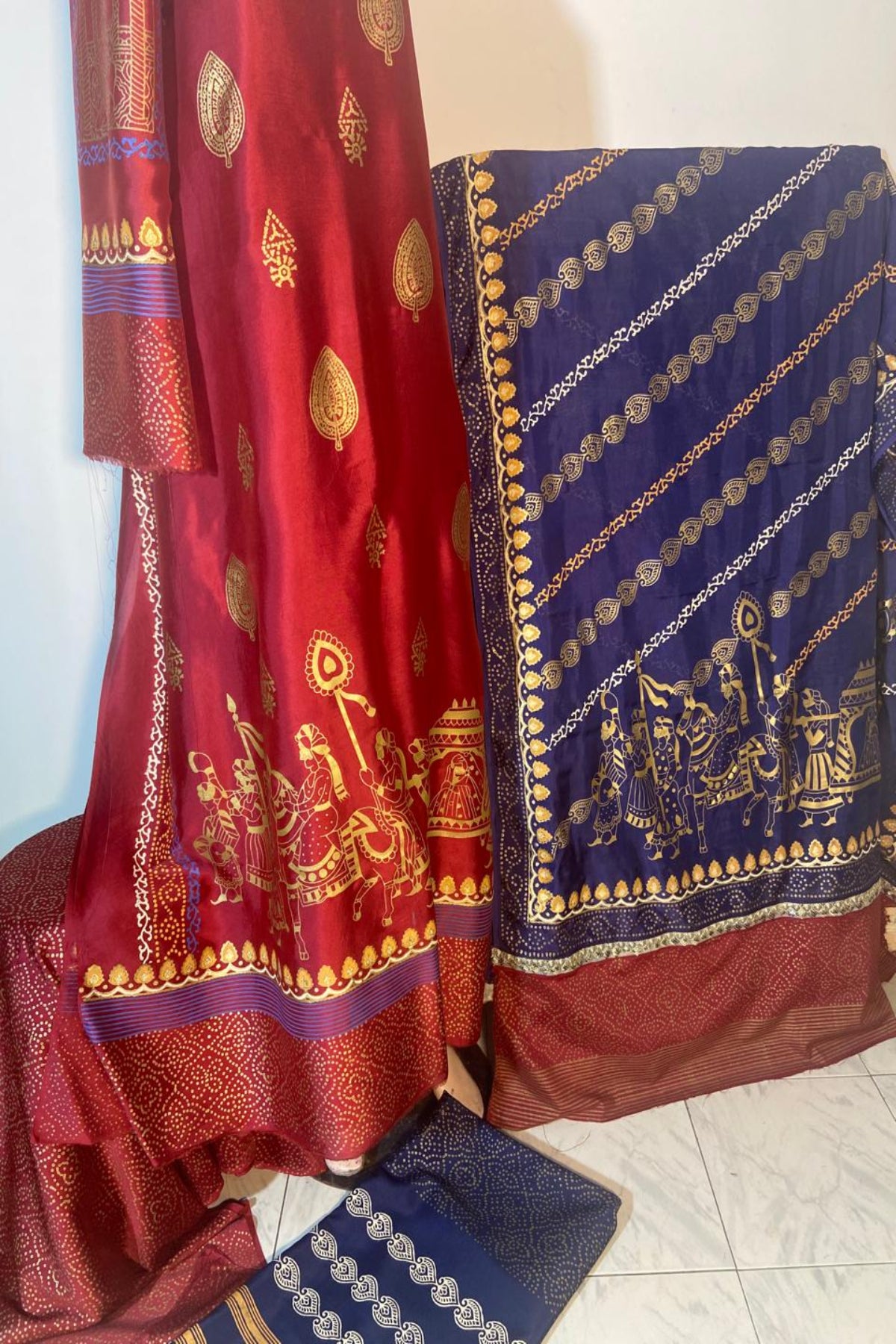 A 3-piece Zariyat by Sumera suit featuring intricate traditional block print patterns in gold on a maroon shirt and deep blue dupatta, complete with matching bottoms